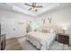Comfortable bedroom with tray ceilings, hardwood floors, neutral colors, and view to bathroom at 980 Prince Garrett Way, Denver, NC 28037