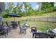 Outdoor patio with comfortable seating, umbrella, fire pit, and a scenic, wooded backyard at 980 Prince Garrett Way, Denver, NC 28037