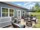 Back patio features chairs, an umbrella, fire pit, and green lawn at 980 Prince Garrett Way, Denver, NC 28037