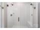 Tiled shower boasts dual shower heads, a built-in bench, and sleek glass doors at 980 Prince Garrett Way, Denver, NC 28037