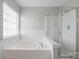 Bright bathroom featuring a soaking tub, and a glass shower at 10008 King George Ln, Waxhaw, NC 28173