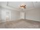 Spacious bedroom featuring a tray ceiling, ceiling fan, and neutral carpet flooring at 10008 King George Ln, Waxhaw, NC 28173
