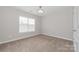 Bedroom with neutral carpet flooring, one window and modern ceiling light at 10008 King George Ln, Waxhaw, NC 28173