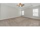 A bedroom with neutral paint, carpeted floors, a tray ceiling and a ceiling fan at 10008 King George Ln, Waxhaw, NC 28173