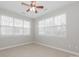 A bedroom with neutral paint, tile floors, a ceiling fan and several windows at 10008 King George Ln, Waxhaw, NC 28173