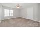 Neutral bedroom features a ceiling fan, bright window, and door at 10008 King George Ln, Waxhaw, NC 28173