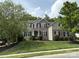 Charming two-story home with a well-manicured lawn, stone accents, and mature trees at 10008 King George Ln, Waxhaw, NC 28173