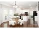 Open kitchen featuring white cabinets, hardwood floors, an island, and dining area at 10008 King George Ln, Waxhaw, NC 28173