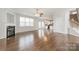 Spacious living room with hardwood floors, fireplace, ceiling fan, and seamless flow to the kitchen at 10008 King George Ln, Waxhaw, NC 28173