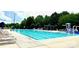 Community pool with lounge chairs and umbrella tables at 10008 King George Ln, Waxhaw, NC 28173