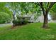 Backyard featuring a white picket fence, a screened-in porch and mature shade trees at 10434 Blackstock Rd, Huntersville, NC 28078