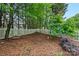 Leafy backyard features a white picket fence for privacy and a variety of trees and greenery at 10434 Blackstock Rd, Huntersville, NC 28078