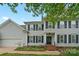 Traditional two-story home with black shutters, manicured lawn, and covered front porch at 10434 Blackstock Rd, Huntersville, NC 28078