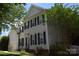 Charming two-story home with gray siding, black shutters, landscaped yard, and manicured greenery at 10434 Blackstock Rd, Huntersville, NC 28078