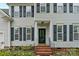 Inviting entryway with red brick steps, black shutters, and manicured landscaping at 10434 Blackstock Rd, Huntersville, NC 28078