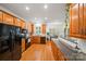 Well-lit kitchen with oak cabinets, black appliances, and a view into the dining area at 10434 Blackstock Rd, Huntersville, NC 28078