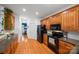 Kitchen with oak cabinets, black appliances, and hardwood flooring with a view of the dining room at 10434 Blackstock Rd, Huntersville, NC 28078