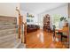 Bright living room featuring hardwood floors, stairs, built-in bookshelf, and comfortable sofa at 10434 Blackstock Rd, Huntersville, NC 28078