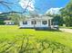 Charming exterior of a bright white home with well-manicured front lawn, and natural wooden posts at 1052 S Grove Street Ext, Lincolnton, NC 28092
