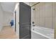 Contemporary bathroom with a tub, shower, neutral tile, and a gray door leading to a bedroom at 1141 Harper Lee Dr, Newton, NC 28658