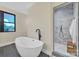 This primary bathroom features a soaking tub with a modern faucet and a glass enclosed shower at 1141 Harper Lee Dr, Newton, NC 28658