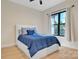The bedroom has a queen bed, large window, and wood laminate flooring at 1141 Harper Lee Dr, Newton, NC 28658