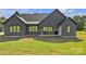 View of the backyard featuring a modern, gray home with a covered patio and lush green lawn at 1141 Harper Lee Dr, Newton, NC 28658