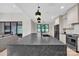 This kitchen showcases a large center island with black fixtures and views of the backyard through a window at 1141 Harper Lee Dr, Newton, NC 28658