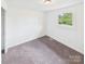 Bright bedroom with neutral walls, carpet flooring, and a window offering natural light, creating a serene space at 120 Hepler Rd, Taylorsville, NC 28681
