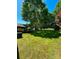 Expansive backyard with large shade trees and open green space, plus an screened outdoor structure at 13416 Four Oaks Ln, Matthews, NC 28105