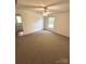 Bright bedroom featuring a ceiling fan, neutral carpet, and ample natural light at 13416 Four Oaks Ln, Matthews, NC 28105