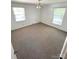 Bright bedroom with two windows, neutral carpet, and natural light at 13416 Four Oaks Ln, Matthews, NC 28105