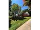 Single-story brick home with a lush, green lawn and mature shade trees in a residential neighborhood at 13416 Four Oaks Ln, Matthews, NC 28105
