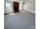 Cozy living room featuring a brick fireplace, large windows, and neutral carpet at 13416 Four Oaks Ln, Matthews, NC 28105