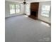 Bright living room with a brick fireplace and large windows at 13416 Four Oaks Ln, Matthews, NC 28105