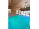 Screened-in porch with brick walls, wood ceiling, ceiling fans and bright blue carpet at 13416 Four Oaks Ln, Matthews, NC 28105