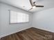 Bright bedroom featuring wood floors, a ceiling fan, and a large window with white blinds at 1348 Green Oaks Ln # L, Charlotte, NC 28205