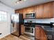 Efficient kitchen featuring stainless steel appliances, wood cabinetry, and granite countertops for a modern touch at 1348 Green Oaks Ln # L, Charlotte, NC 28205