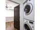 Stacked white washer and dryer with a dark brown door leading to a bedroom at 1348 Green Oaks Ln # L, Charlotte, NC 28205