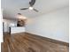 Open-concept living room with ceiling fan and wood-look floors adjacent to kitchen area at 1348 Green Oaks Ln # L, Charlotte, NC 28205