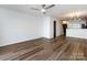 Open-concept living room with ceiling fan and wood-look floors adjacent to kitchen area at 1348 Green Oaks Ln # L, Charlotte, NC 28205