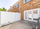 Fenced patio area with concrete slab and white rock landscaping and walk-out doors at 1348 Green Oaks Ln # L, Charlotte, NC 28205