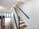Elegant staircase showcasing wood steps, white risers, and dark trim, leading to the upper level at 1348 Green Oaks Ln # L, Charlotte, NC 28205