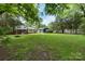 Expansive backyard featuring mature trees, a fire pit, and a detached garage or shed at 15333 Catawba S Cir, Matthews, NC 28104