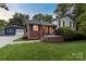 Quaint home with brick accents, a well-maintained lawn, and a detached garage at 15333 Catawba S Cir, Matthews, NC 28104