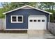 Detached garage with white door and a window with dark shutters at 15333 Catawba S Cir, Matthews, NC 28104