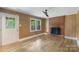 Living room featuring wood-paneled walls, brick fireplace, door to outside and window at 15333 Catawba S Cir, Matthews, NC 28104