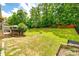 Lush backyard featuring mature trees, a fire pit, a garden, and ample space for outdoor activities at 1655 Essex Hall Dr, Rock Hill, SC 29730