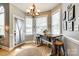 Bright breakfast nook features a wooden table, three windows, and a charming chandelier at 1655 Essex Hall Dr, Rock Hill, SC 29730