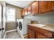 Functional laundry room with washer, dryer, wooden cabinets, and a sink at 1655 Essex Hall Dr, Rock Hill, SC 29730